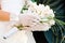 Wedding day. Bride in white gloves holds a wedding bouquet of white orchids closeup.