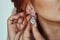 Wedding day. Earrings close-up in the hands of the bride. jewelry accessories