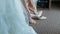 Wedding day. Young girl\'s hand puts on shoes and strokes her legs