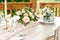 Wedding decoration table in the garden, floral arrangement,candles In the style vintage on outdoor. Wedding cake with flowers.