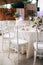 Wedding dinner table reception. A close-up of the white classical chair for Chiawari`s wedding, Tiffany near the round