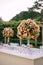 Wedding dinner table reception. Huge bouquets of yellow, pink, orange roses and green hydrangeas in a glass vase on a