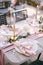 Wedding dinner table reception. Stone table with pink runner, plates with pattern and rag pink napkins, candles with led