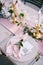 Wedding dinner table reception. Stone table with pink runner, plates with pattern and rag pink napkins, candles with led