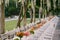 Wedding dinner table reception. A very long table for guests with a white tablecloth, floral arrangements, glass plastic