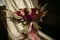 A wedding disheveled bouquet with burgundy dahlias and cream-colored roses with ribbons stands on a chair, lit by the sun.