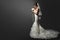 Wedding Dress. Bride in white Gown. Bridal Fashion Model holding Flower Bouquet. Profile View over Black Background. Copy space