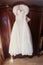 Wedding dress hangs on a vintage wardrobe