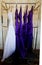 Wedding dress and purple bridesmaid dresses hanging on a bell cart