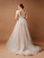 Wedding fashion. Elegant brunette model in backless ivory lace wedding dress with long sleeves.