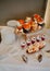 Wedding menu. Serving a wedding candy bar. A composition of sweet cakes and cookies, desserts in cups and roses in a vase on a
