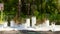 Wedding party banquet outdoors in pine forest. Dining tables decorated in boho style with candles in glass vases, white