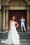 Wedding photo with bride and groom. Beautiful bride posing against the background of the groom and the Catholic Church