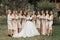 Wedding photo in nature. A brunette bride in a long white dress stands in front of her