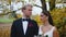 Wedding photoshoot during golden autumn season. Positive young couple - Turkish woman and Scandinavian man - standing