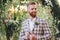 Wedding portrait of man with red beard and hipster hairstyle in stylish vintage clothing. Bearded groom posing in plaid