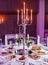 Wedding reception dinner. Round table served with flowers, shiny candles and appetizer food. Holiday banquet menu