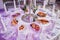 Wedding reception dinner. Round table served with flowers, shiny candles and appetizer food. Holiday banquet menu