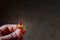 Wedding ring in the hand of the groom, a young man holds a ring with his fingers . view of a golden engagment ring