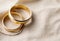 Wedding rings on beige fabric with copy space