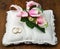 Wedding rings with roses on bridal pillow