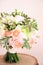 Wedding round bouquet with white freesia flower, green dianthus, peach roses, light chrysanthemum and fresh greens. Bridal bouquet