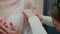 Wedding salon consultant helps a bride try on a lace wedding dress. Close-up.Slow motion