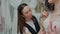 Wedding salon consultant helps a bride try on a lace wedding dress. Close-up.Slow motion