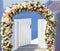 Wedding at Santorini. Beautiful arch decorated with flowers of roses with  blue church of Oia, Santorini, Greece at most romantic