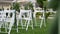 Wedding set up in garden, park. outside wedding ceremony, celebration. wedding aisle decor. Rows of white wooden empty