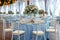 Wedding setup blue covered round tables in a pristine pavilion