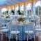 Wedding setup blue covered round tables in a pristine pavilion