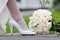 Wedding shoe and bridal bouquet. Female feet in white wedding shoes and bouquet close-up.