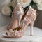 wedding shoes on a white table in a room with flowers