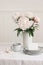 Wedding still life scene. Business, place card mockup scene, marble tray, cup of coffee an pink peony flowers in vase