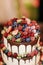 Wedding Strawberry blueberry raspberry berries cake with chocolate on a wooden background in evening outdoor. Close up
