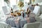 A wedding table for guests decorated with flowers and a tablecloth in a designer style with food and drinks. Decor and design of