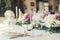 Wedding table settings with flowers decoration and candles, close up on whine glasses