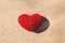 Wedding two gold rings on a red pillow heart shape over craft paper background