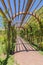 Wedding venue with a wooden arbor and stone brick pathway under sunny blue sky