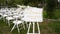 Wedding welcome sign decorations for outdoor wedding ceremony decorated with white roses, natural flowers. White chairs