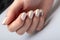 Wedding white pearl manicure on short square nails on a white background close-up