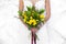 Wedding yellow bouquet in bride`s hands white background