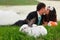 Wedding, young bride kiss groom in love lying on green grass wit