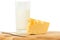 Wedge of cheese, glass of milk and knife on a cheese board