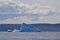 Wedge shaped iceberg under large cloud in bay outside St. John\\\'s