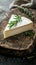 A wedge of soft cheese, white and rich, with a mild flavor profile on a rustic wooden board