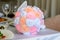 Weding bouquet on a table. Close up photo of beautiful ideal perfect charming orange white and pink silk fabric small wedding brid