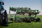Weeding-machine behind tractor on green wheat field