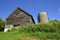 Weeds and foliage in the back of an old barn and silo